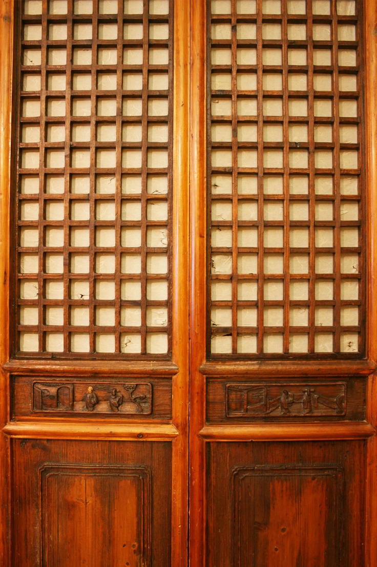 two wooden doors with carved designs on them