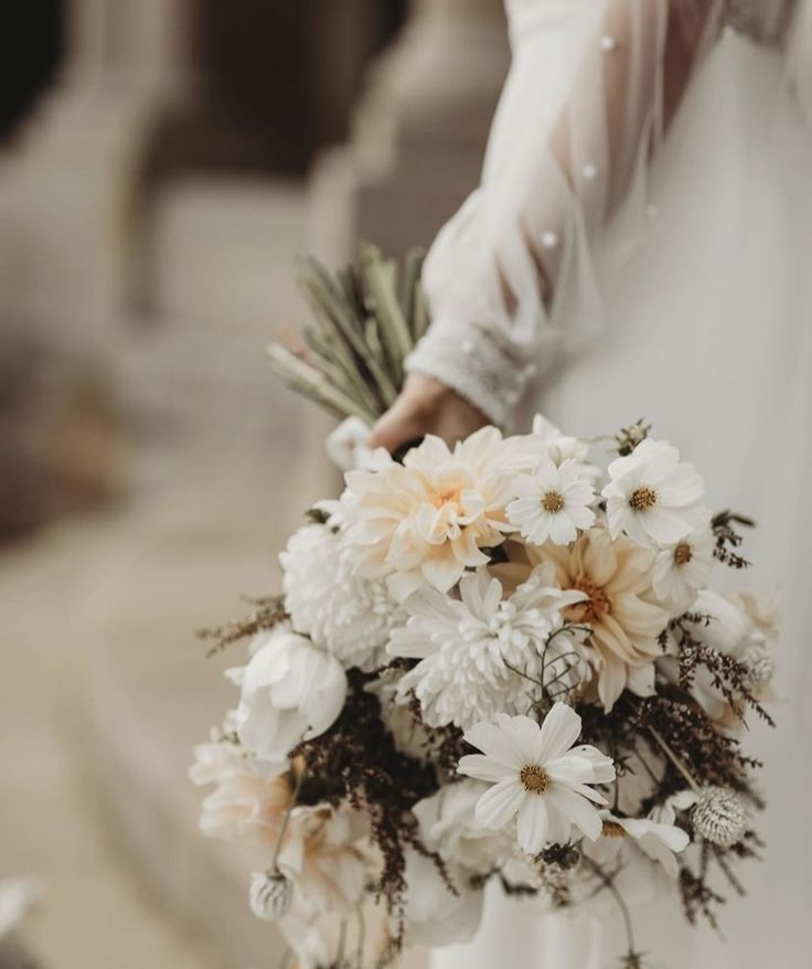 a bride holding a bouquet of flowers in her hand