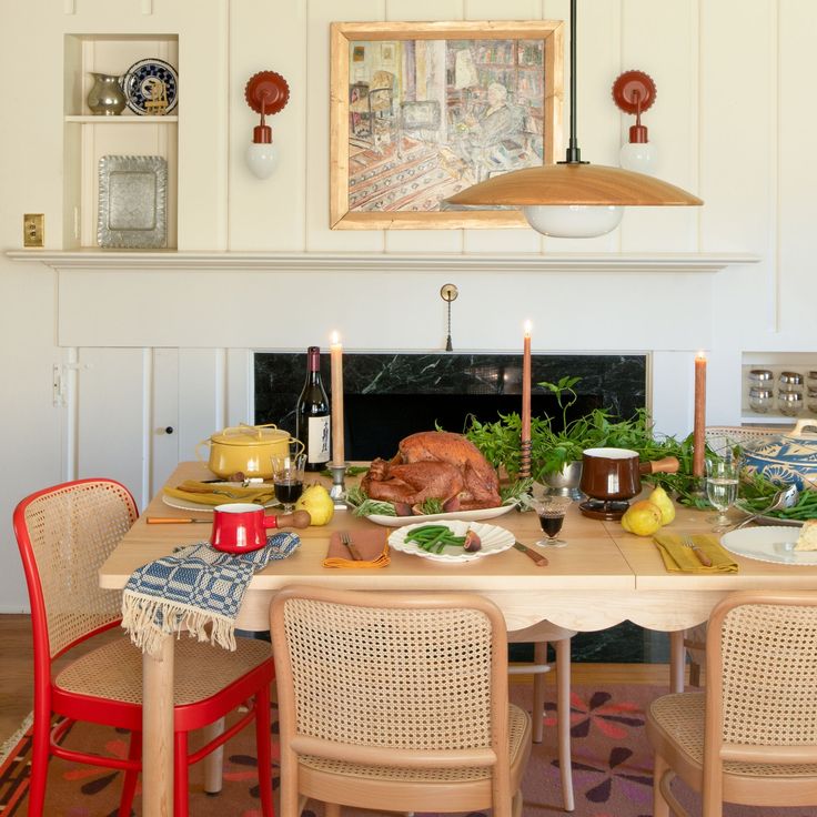 a dining room table is set with food and candles