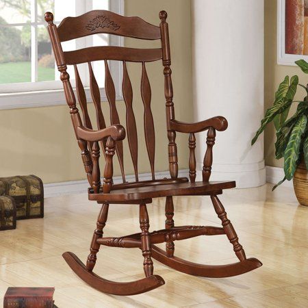 a wooden rocking chair sitting on top of a hard wood floor next to a window