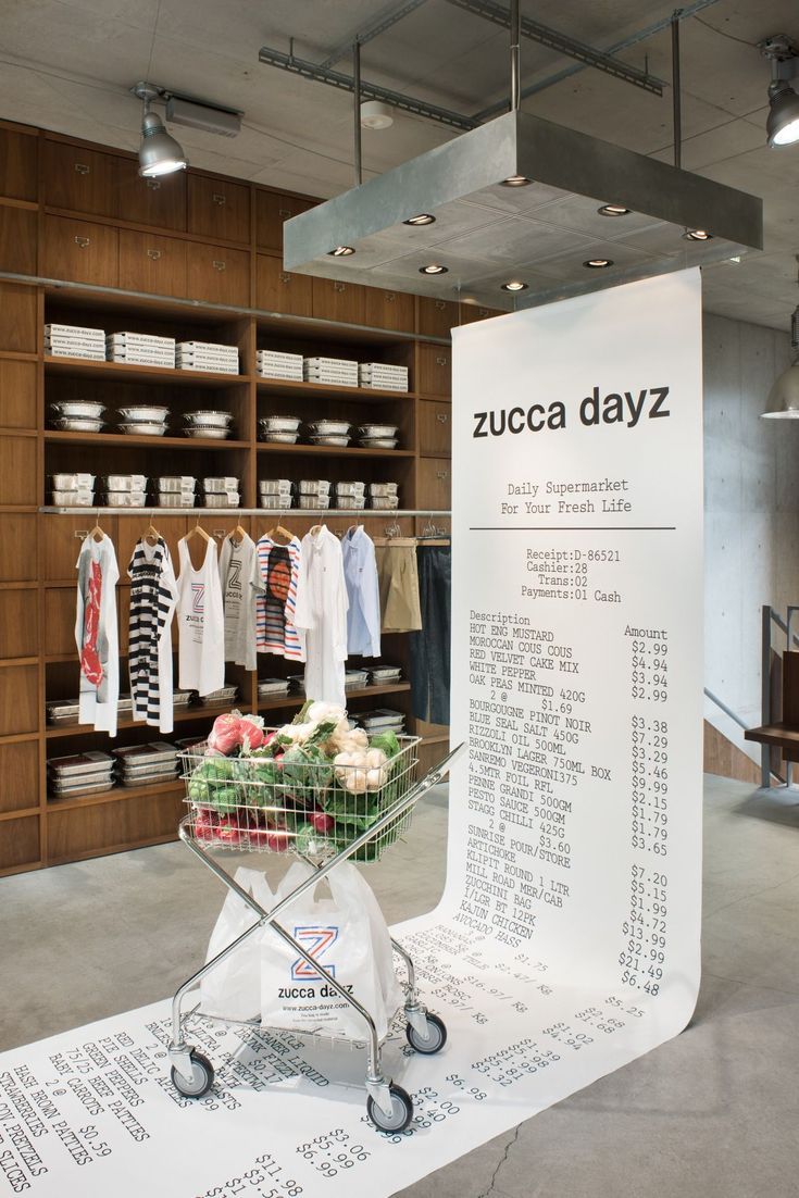 a shopping cart sitting on top of a table in front of a display case filled with clothes