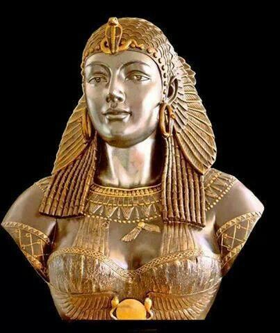 a gold statue of an egyptian woman with her hands in her pockets and headdress