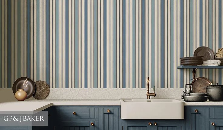 a kitchen with blue cabinets and striped wallpaper