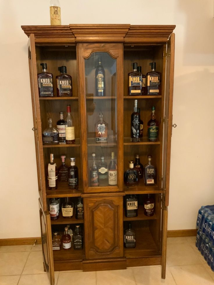 a wooden cabinet filled with lots of liquor bottles