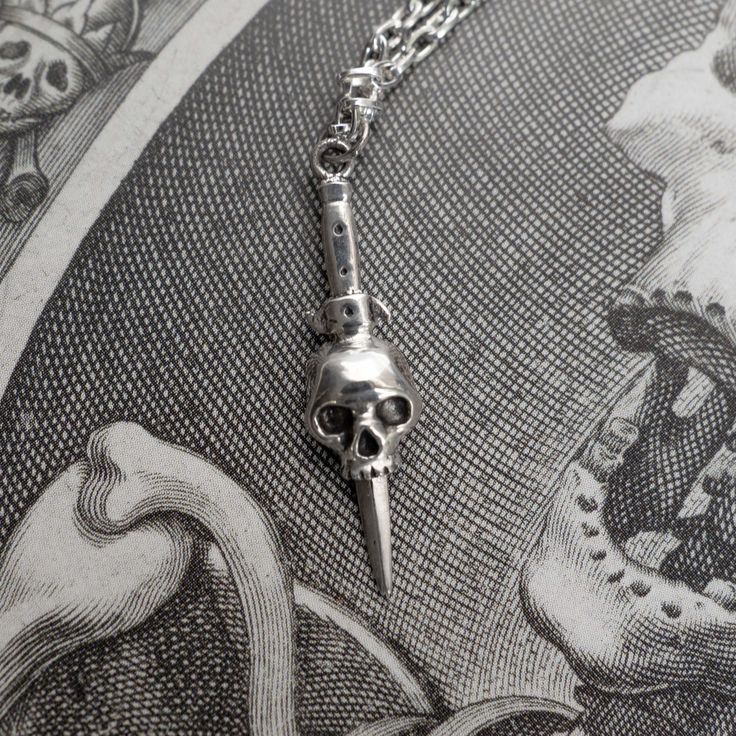 A dagger and skull necklace in sterling silver. Inspired by tattoo design and symbolism - death, protection and bravery.Chain length = 18", 20", 22"and 24"Skull pendant height = 27mmSterling SilverHandmade in NYC Dagger Necklace, Clothing Art, Halloween Vampire, Gothic Horror, Dark Gothic, Skull Jewelry, Skull Necklace, Skull Pendant, Skull Ring