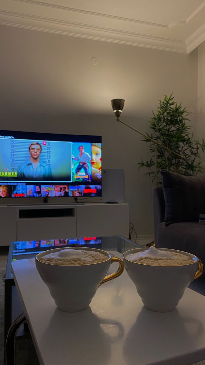 two bowls of oatmeal sit on a table in front of a television