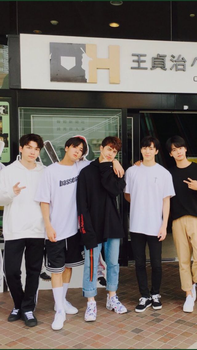 group of young men standing in front of a building