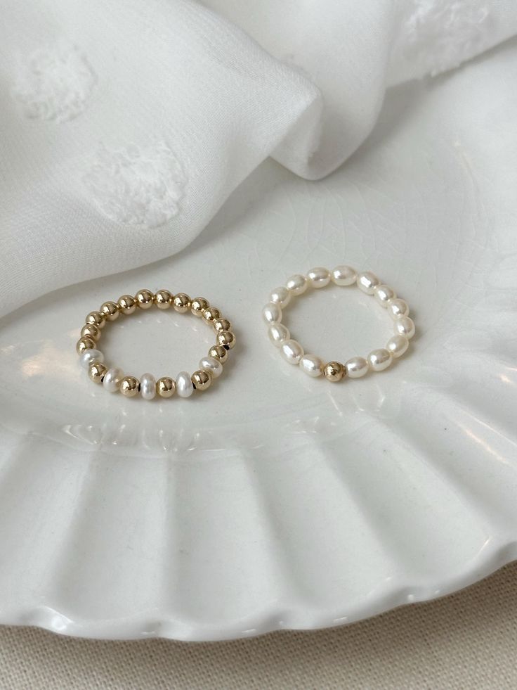 This beaded freshwater Pearl ring set adds elegance to your everyday jewelry look! Each dainty ring is hand beaded just for you! These gorgeous genuine Pearl rings are accented with sensitive skin safe 14K Gold Filled. * 3mm natural freshwater Pearls * 14K Gold Filled accent beads * Rings may be purchased as a set, or single from the drop down menu below. Extra Small ring fits US 4-5 Small ring fits US sizes 6-7 Medium ring fits US sizes 8-9 Large ring fits US sizes 10-11 See all Pearl Jewelry here!: https://etsy.me/3zMbXyh GET TO KNOW MAGBEE JEWELRY!: ✨ 🤍 All MagBee pieces are safe for sensitive skin and made with hypoallergenic Gold Filled or 925 Sterling Silver. 🤍 I only use real/natural gemstones and Pearls. 🤍 Most items are made to order just for you and have a 2-4 day processing t Stretch Rings, Beads Rings, Seed Pearl Ring, Gifts For Friend, Pearl Rings, Small Ring, Freshwater Pearl Ring, Stretch Ring, Zierlicher Ring