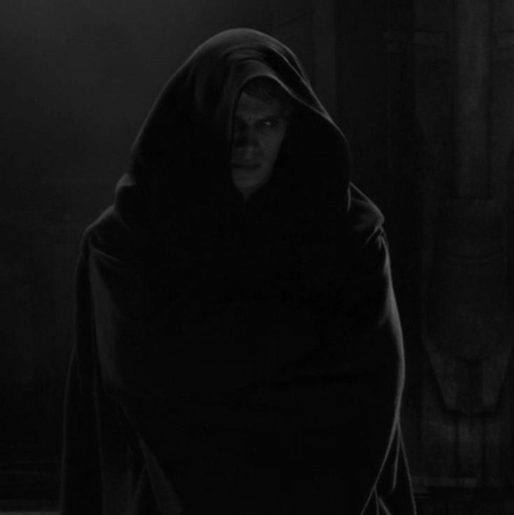 a man in a hooded cloak is looking at the camera