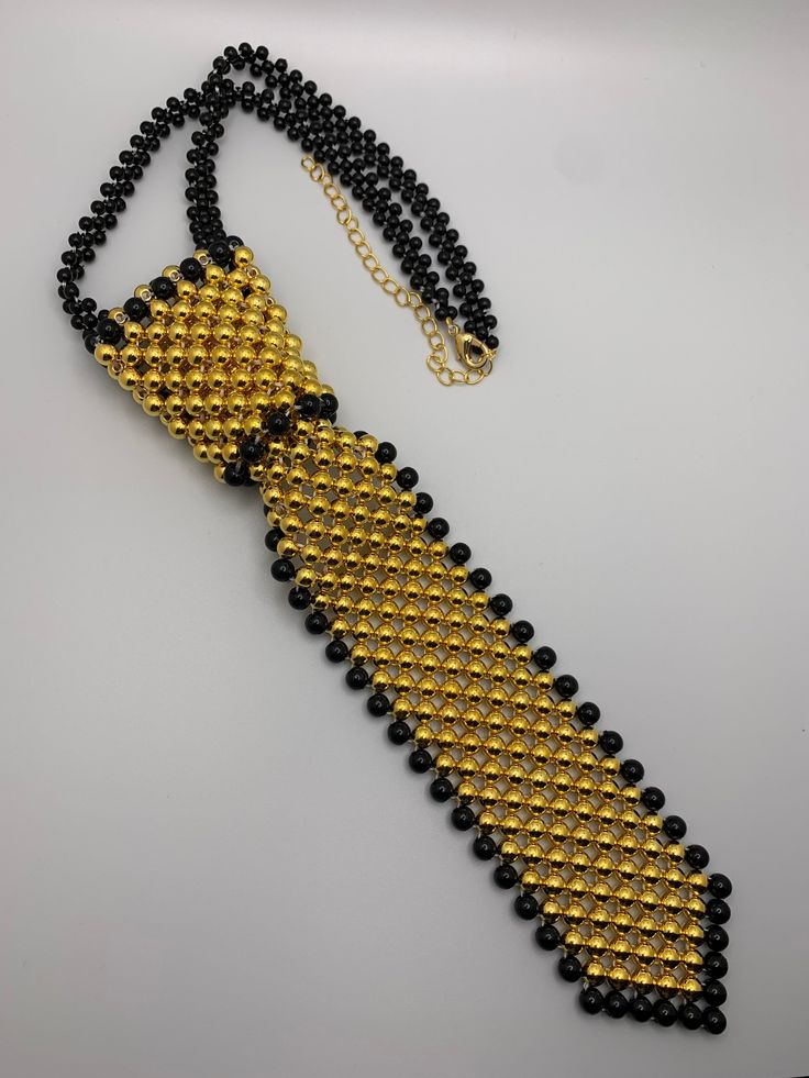 Black and Gold Pearl neck tie High quality gold pearls! Black Jewelry With Ties For Gifts, Black Ties Jewelry For Gift, Gift Black Jewelry With Ties, Classic Jewelry With Ties For Parties, Elegant Gold Necklaces With Black Beads, Elegant Gold Jewelry For Black Tie, Elegant Gold Necklace With Black Beads, Elegant Gold Jewelry For Black Tie Event, Formal Black Jewelry With Gold Beads