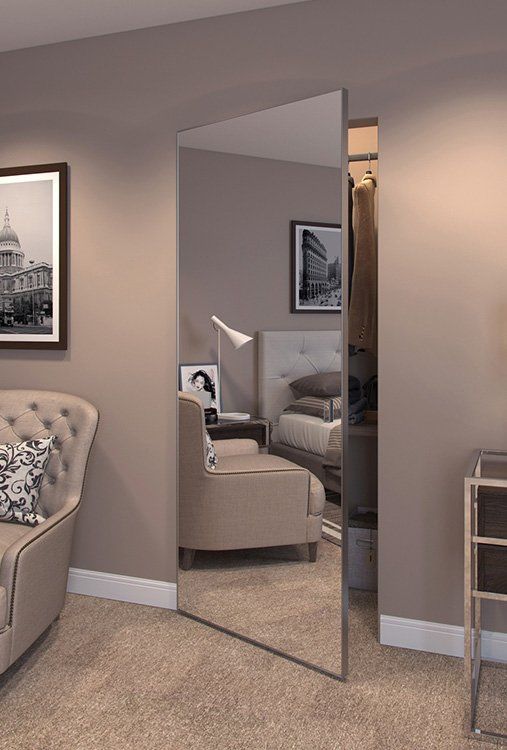 a living room filled with furniture and a large mirror on the wall next to a chair