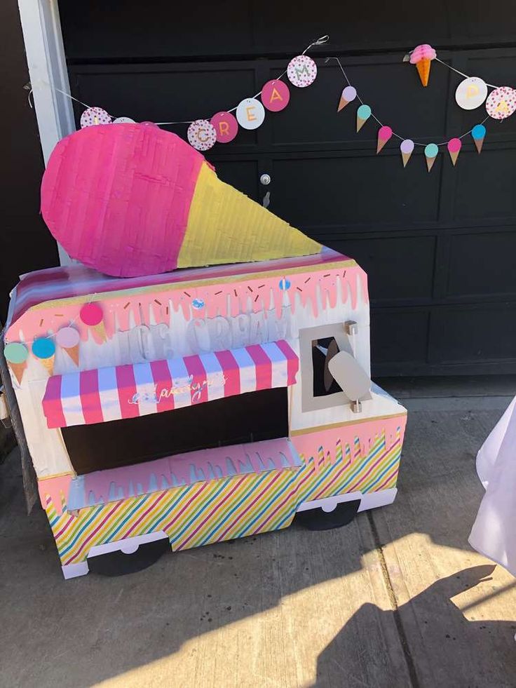 a pink ice cream cart sitting on top of a sidewalk next to a garage door