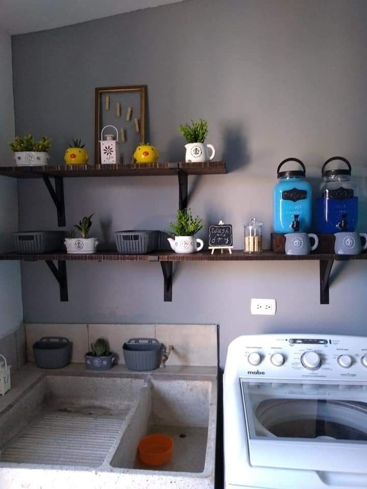 a washer and dryer in a small room with shelves above the washer