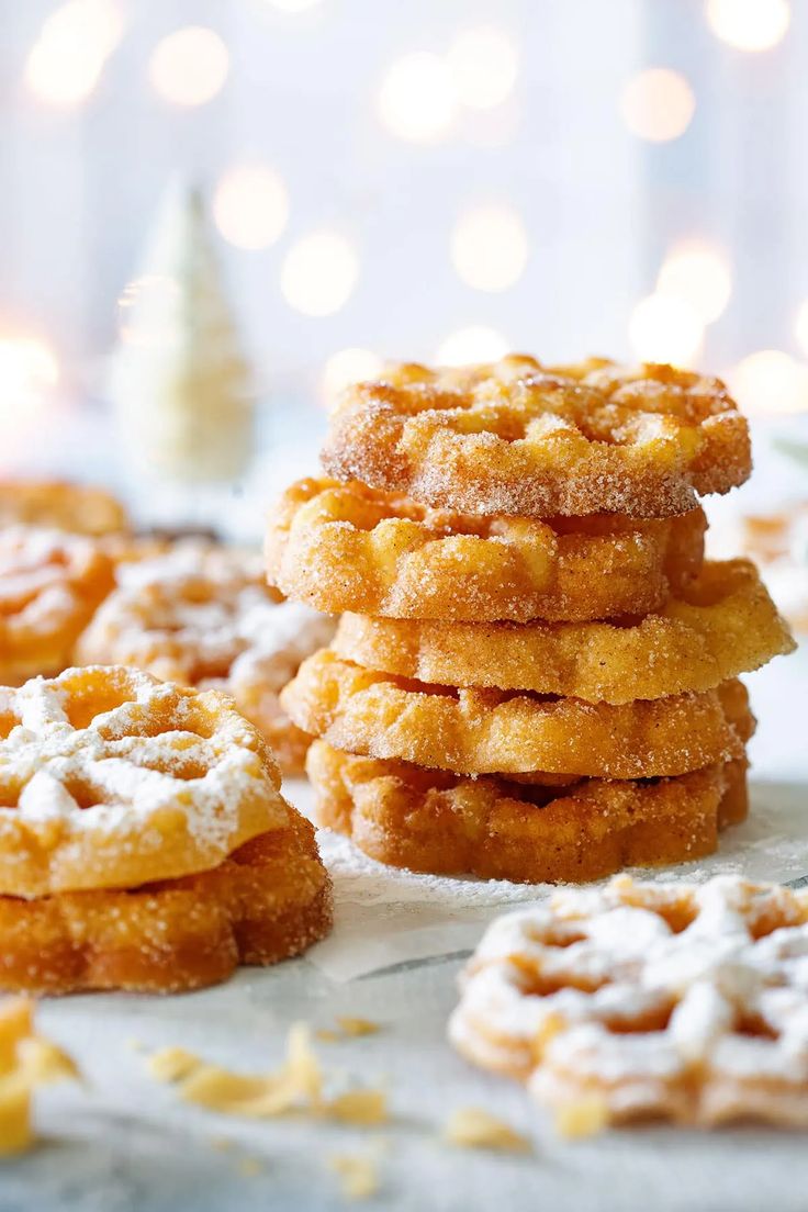 a stack of sugared donuts sitting on top of a table