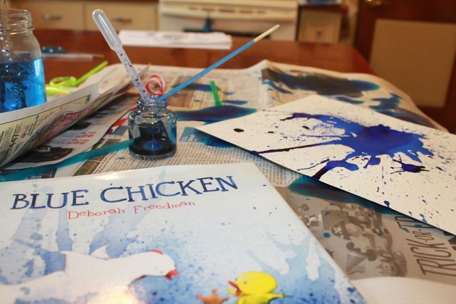 a table topped with books and paints on top of it