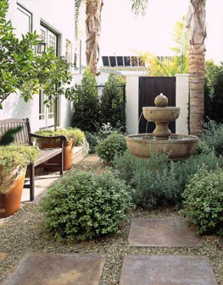 an outdoor fountain surrounded by plants and trees