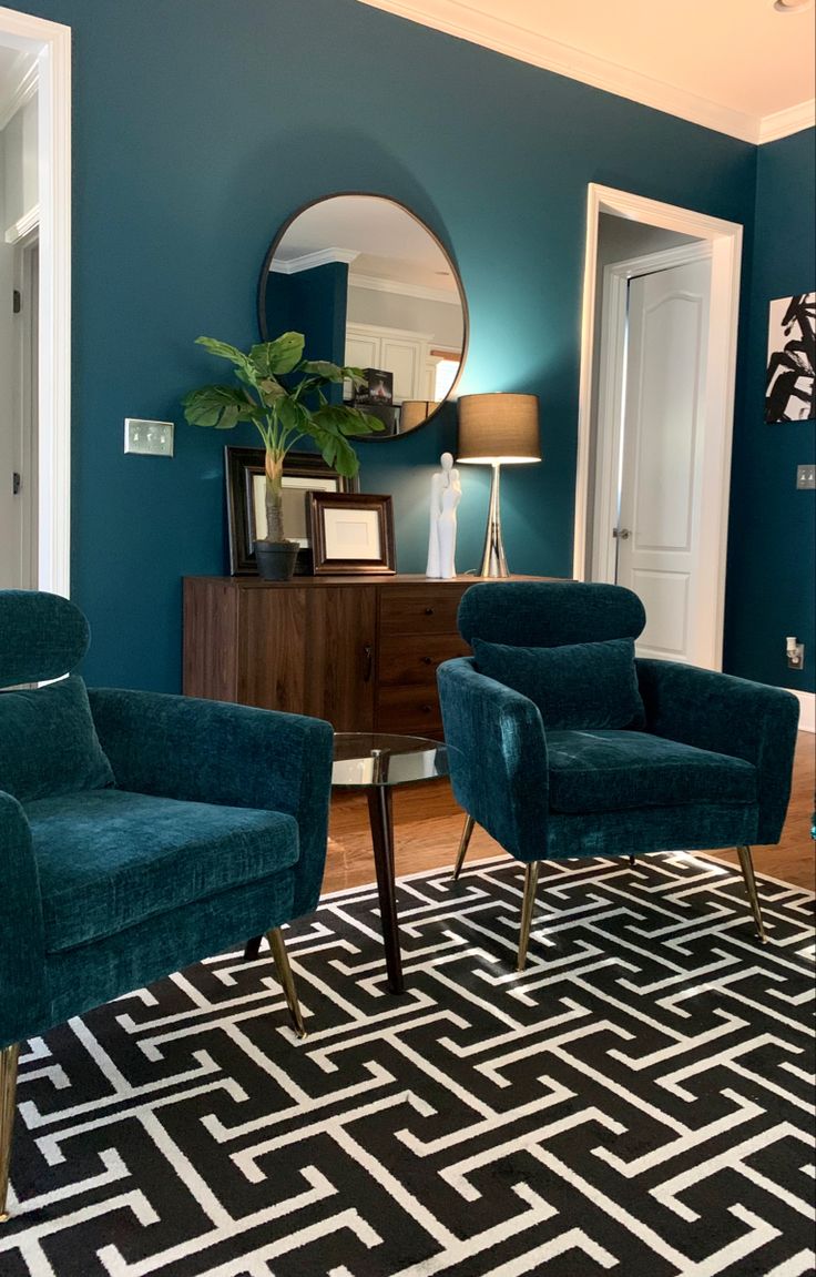 a living room with two chairs and a rug on the floor in front of a mirror