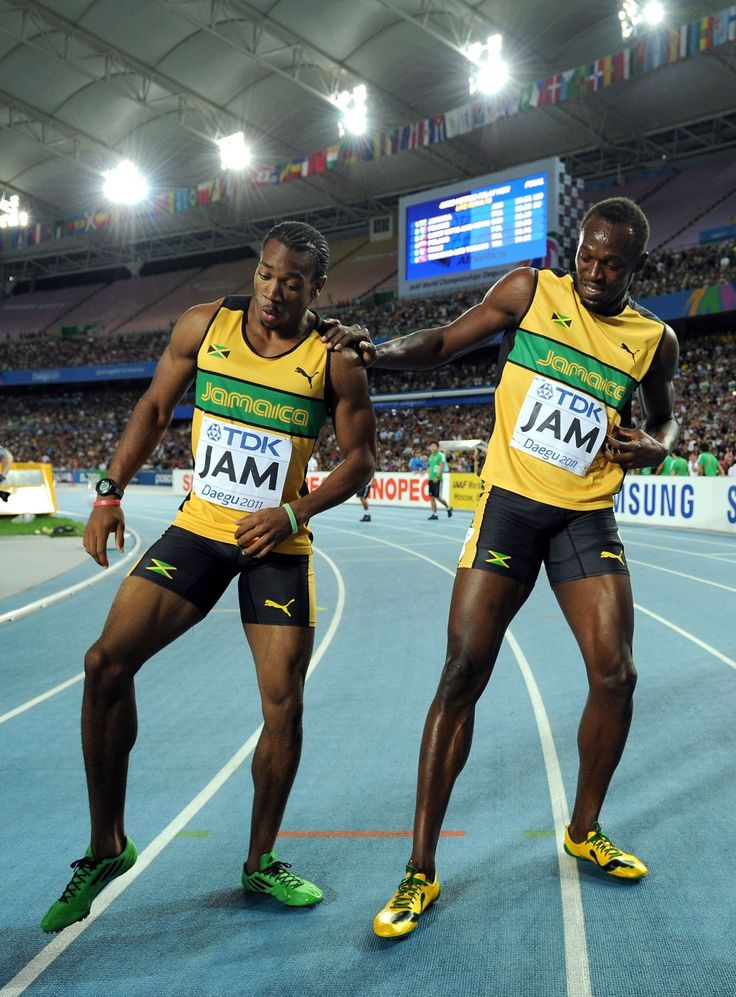 two men standing next to each other on a track