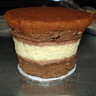 a cake sitting on top of a metal counter covered in frosting and toppings