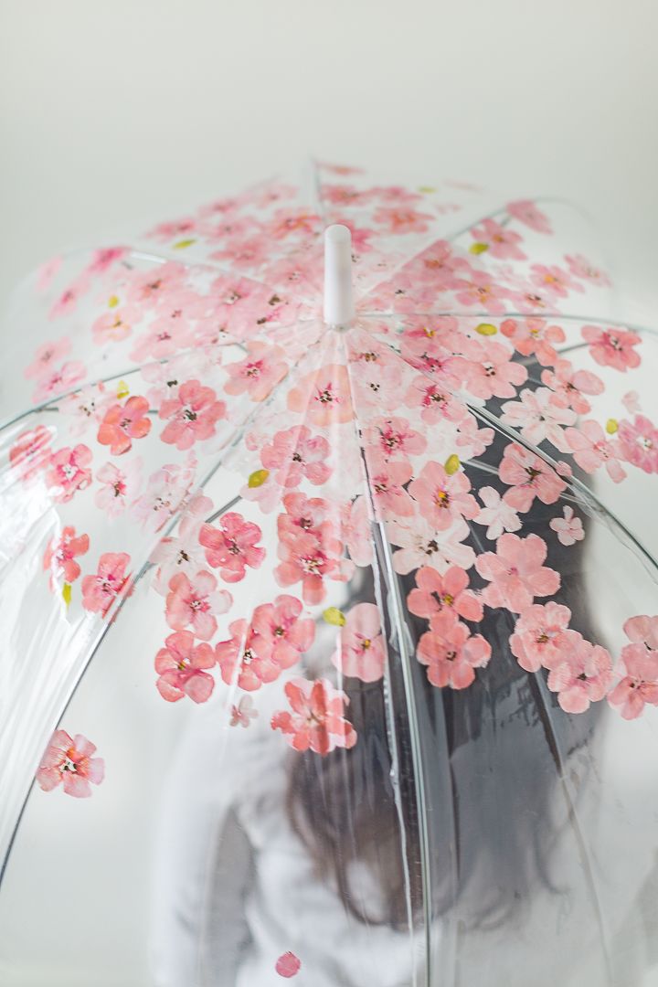 a woman holding an umbrella with pink flowers on it