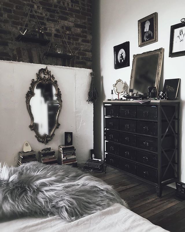 a bedroom with a bed, dresser and pictures on the wall in black and white