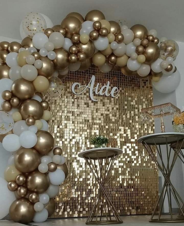 an arch made out of gold and white balloons