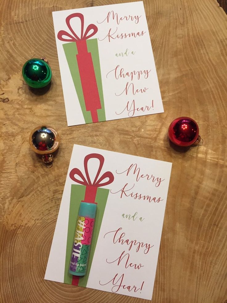 two christmas cards on top of a wooden table next to candles and ornaments with merry new year's greetings written on them