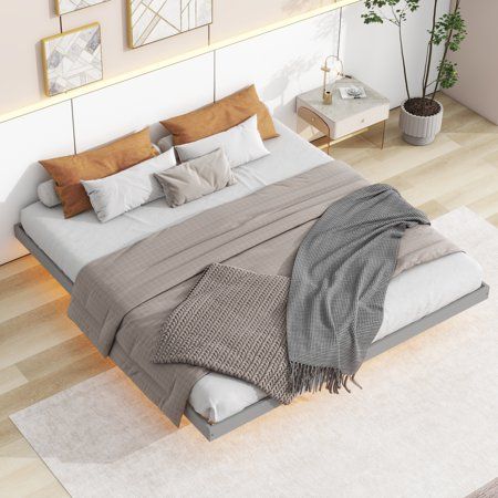 a large bed sitting on top of a hard wood floor next to a white wall