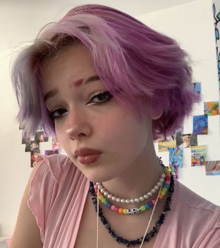 a woman with pink hair and necklaces on her neck