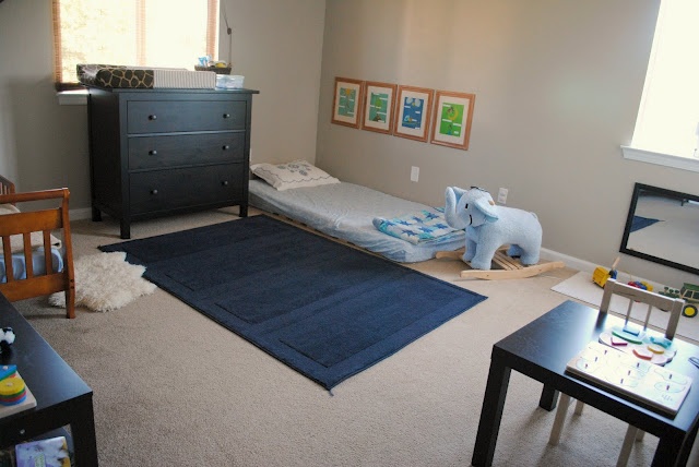 a baby's room with two twin beds and an elephant rug