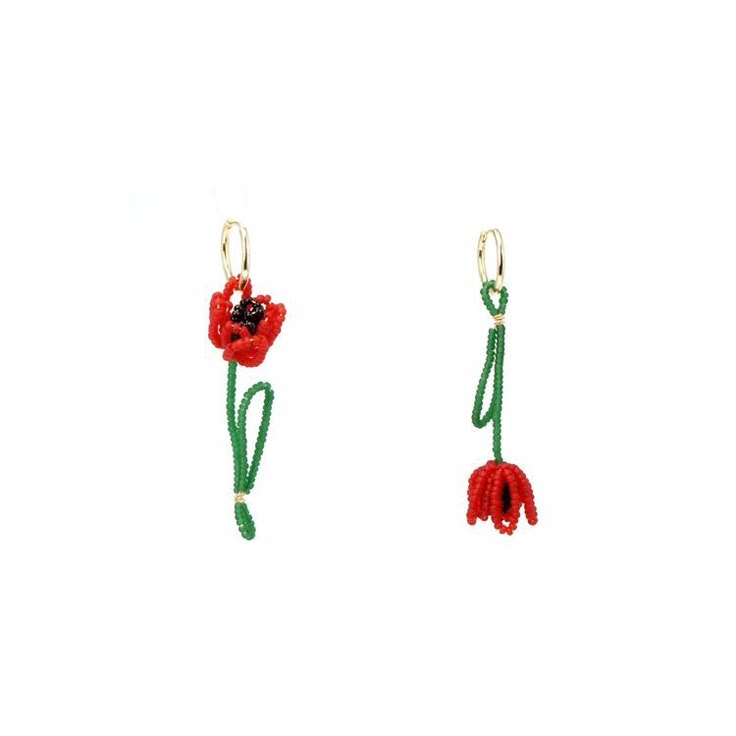 two red flowers with green stems hanging from hooks