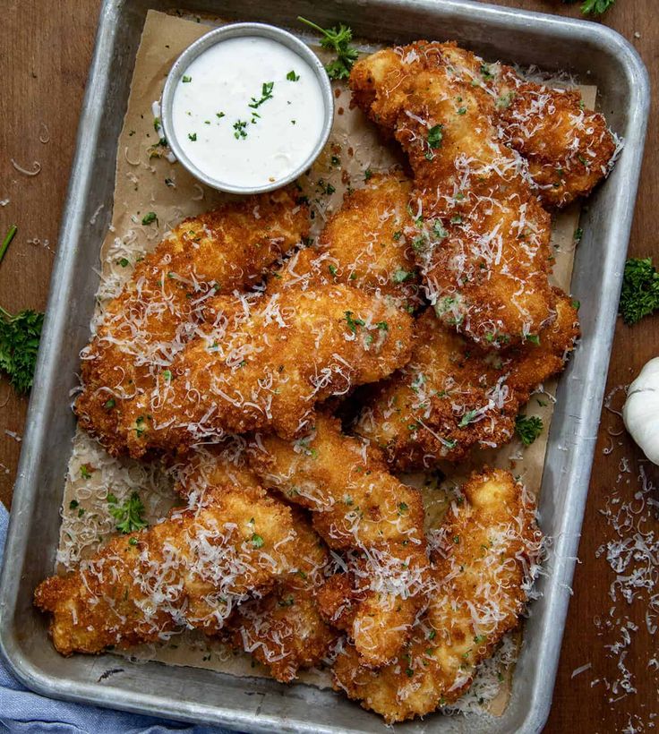 chicken wings with parmesan cheese and ranch dressing on a tray next to garlic