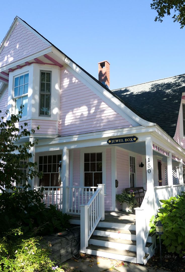 a pink and white house with stairs leading up to it