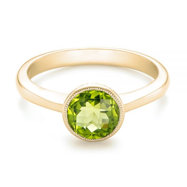 a yellow gold ring with a green stone