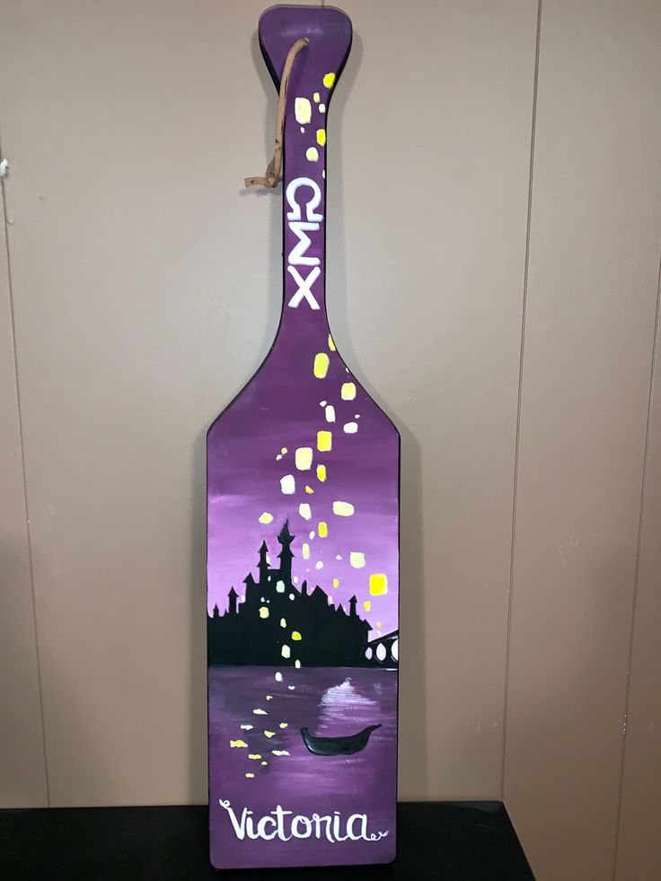 a bottle shaped like a paddle with the name victoria painted on it