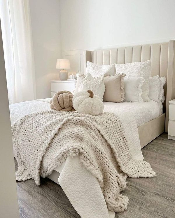 a bed with white blankets and pillows on top of it