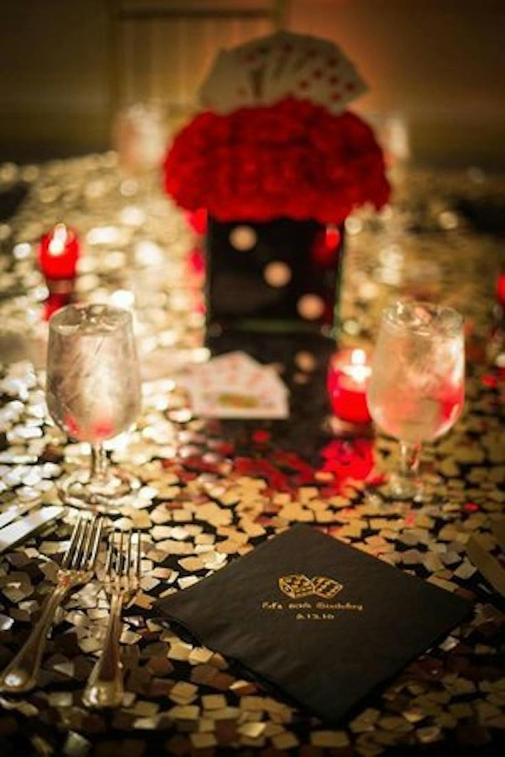 the table is set with silverware and red roses