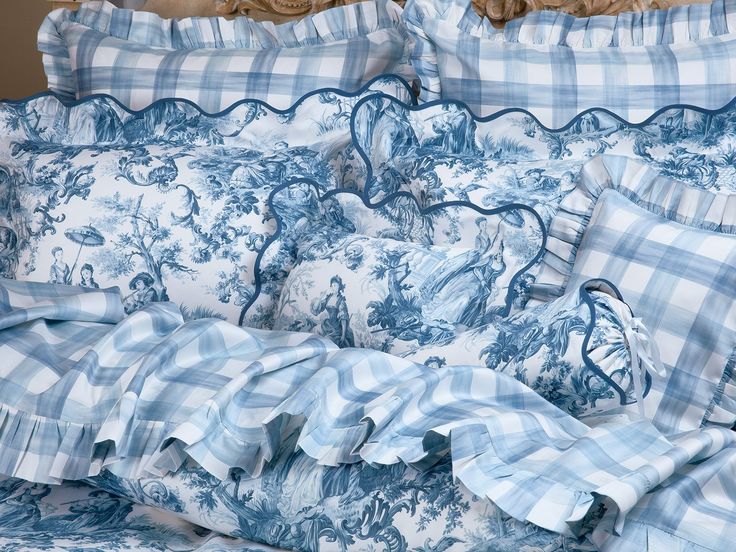 a bed with blue and white comforters on top of it