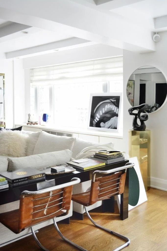 a living room filled with furniture and a mirror