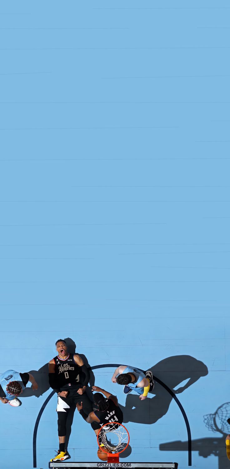 two skateboarders doing tricks in front of a blue background