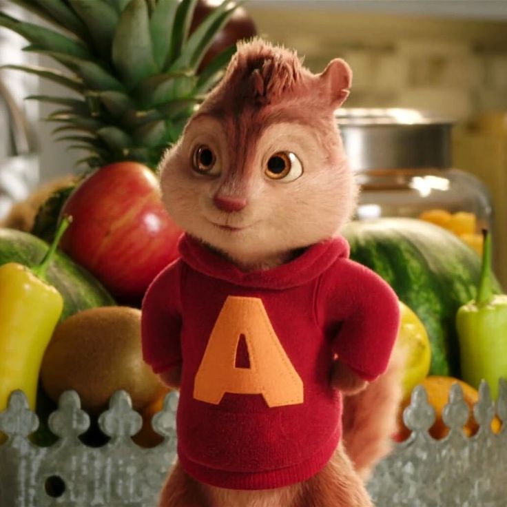 the chipmunz is standing in front of a pile of fruit and veggies