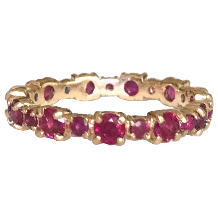 a yellow gold ring with pink stones