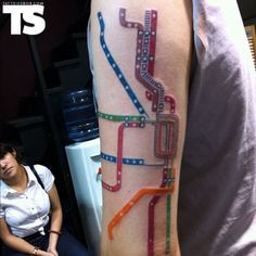 a person with a tattoo on their arm has a colorful train map tattooed on it