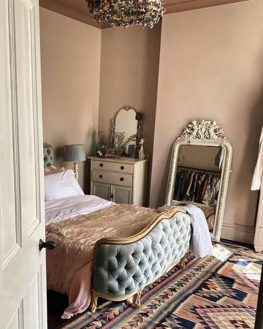 a bed room with a neatly made bed and a mirror on the wall next to it