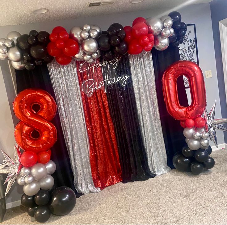 the balloon arch is decorated with red, black and silver balloons