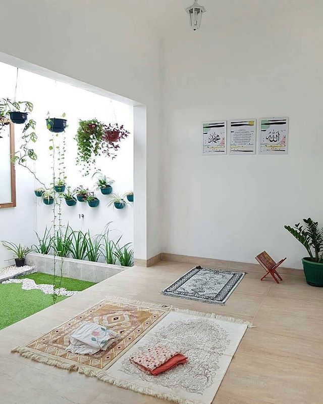 a living room with plants and rugs on the floor