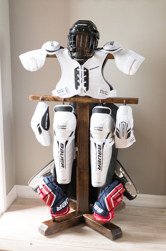 an ice hockey goalie's gear sits on a wooden stand