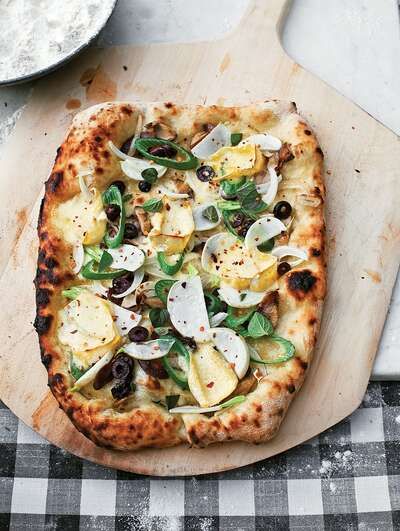 a pizza sitting on top of a wooden cutting board