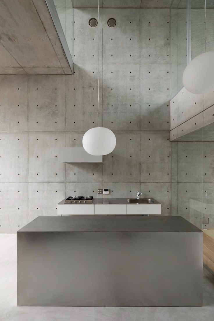 a modern kitchen with concrete walls and flooring