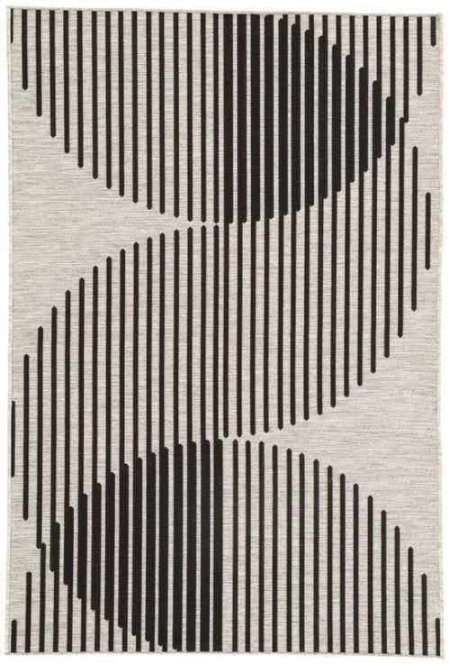 a black and white rug with vertical lines on the floor, in front of a gray background